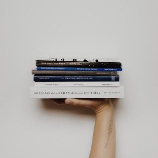 A hand with a pile of books