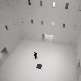 A man standing in the middle of the hall with multiple openings